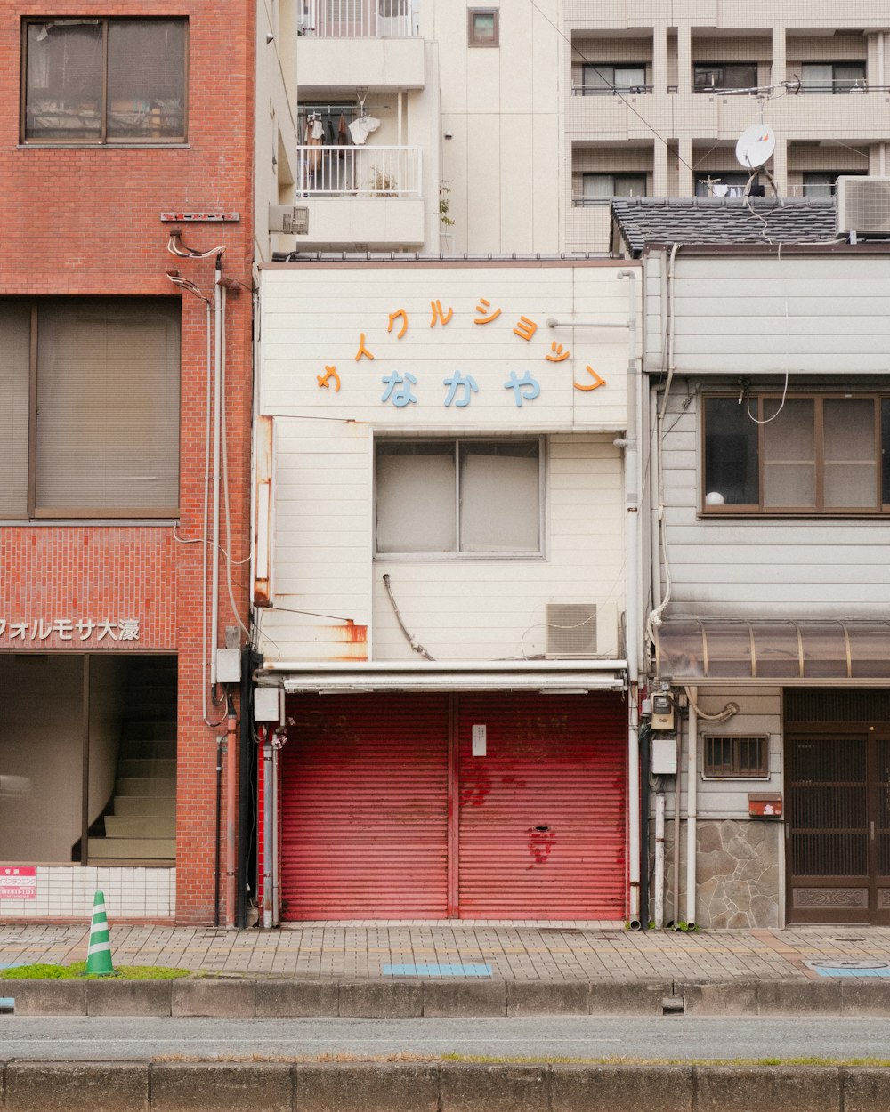 a red fire hydrant sitting in front of a tall building