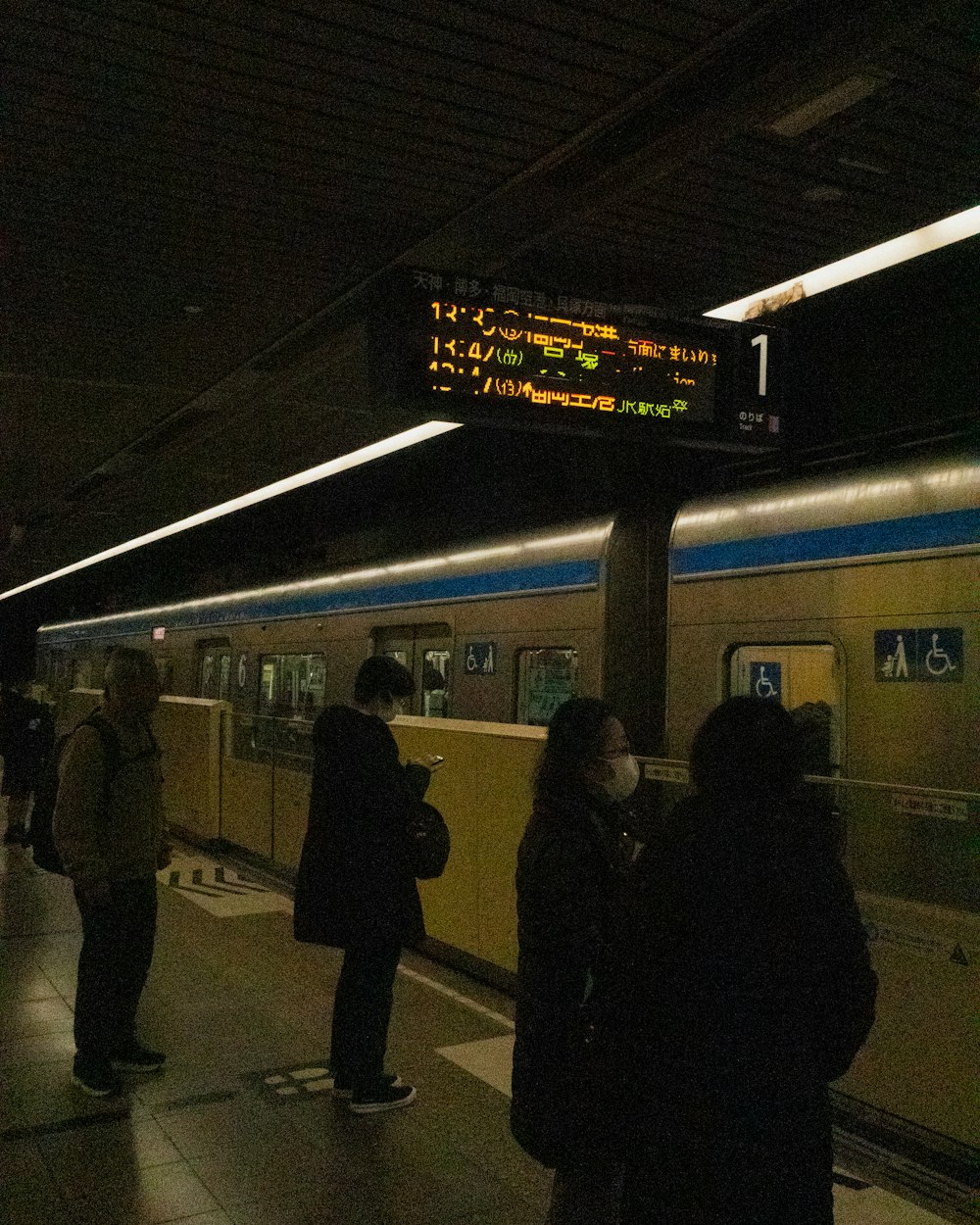 a group of people standing next to a train