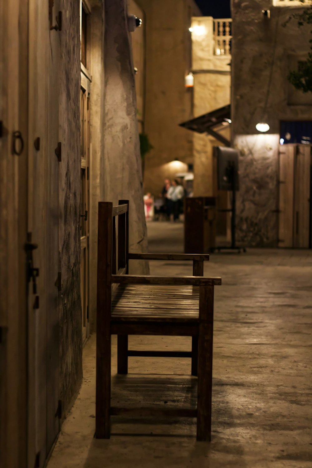 a wooden bench sitting on the side of a building