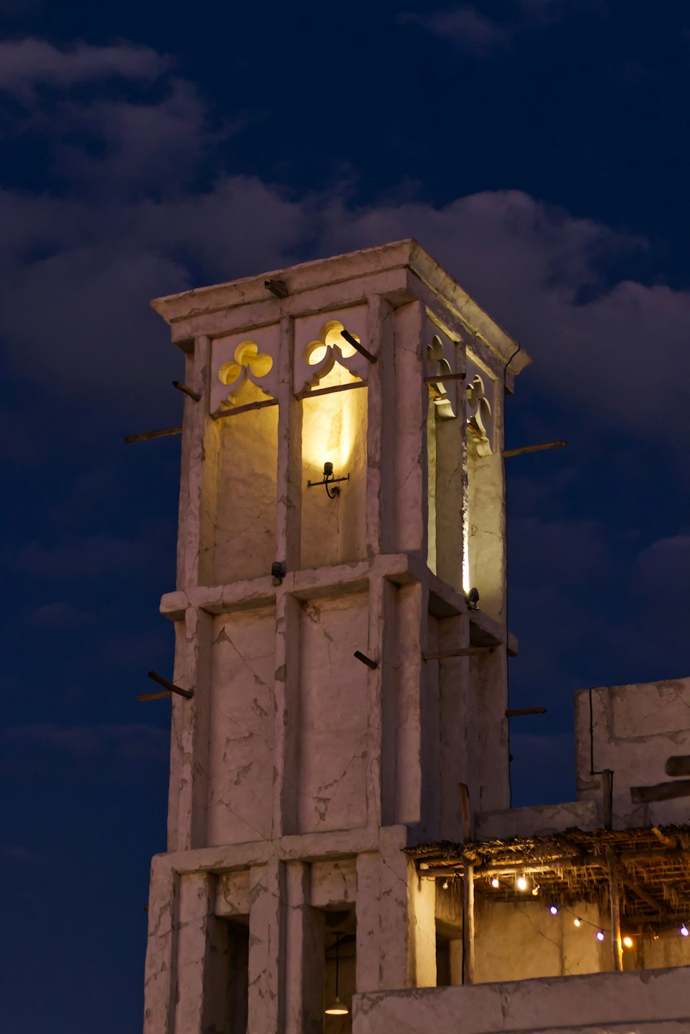 un'alta torre dell'orologio bianca con un orologio su ciascuno dei suoi lati