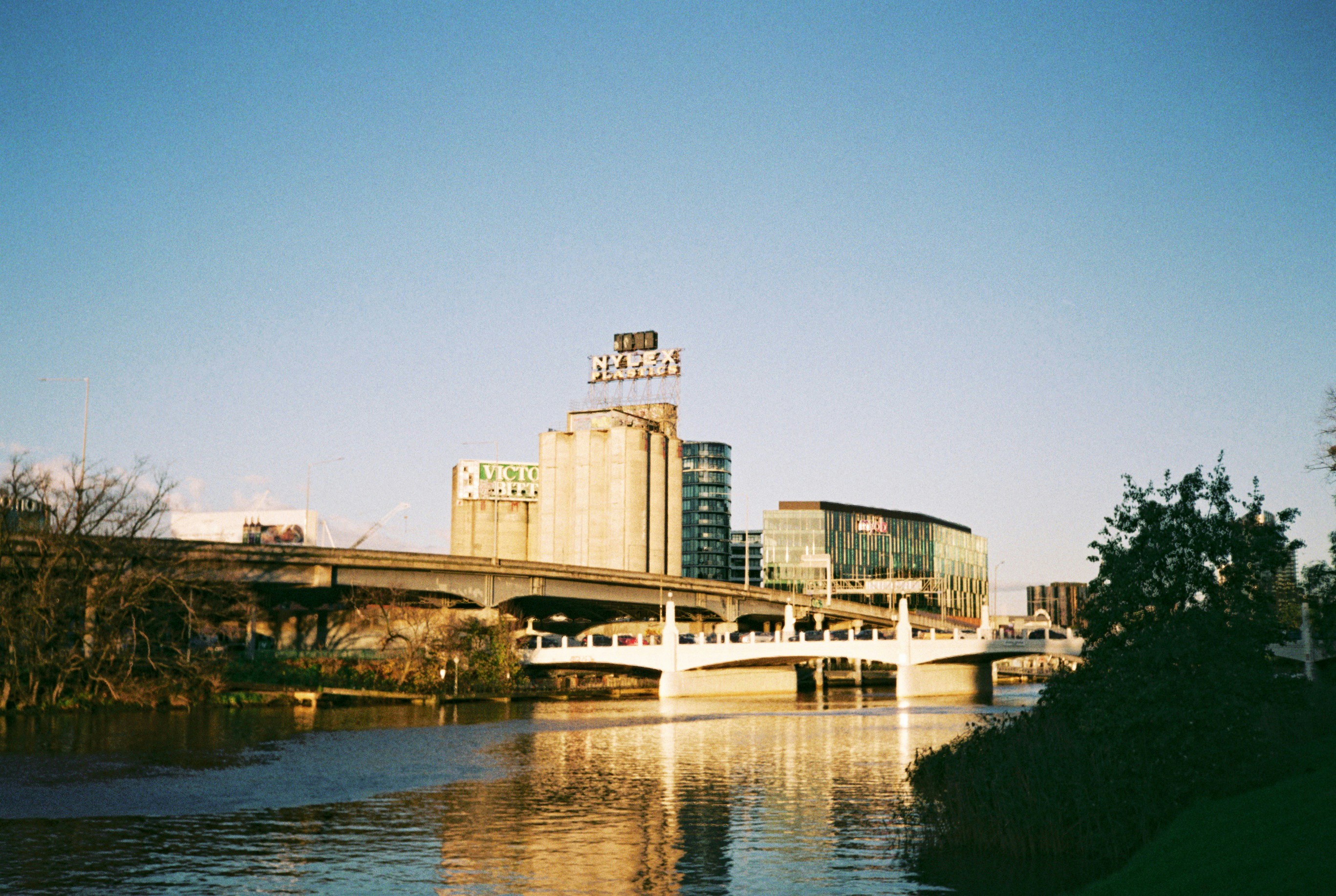 a bridge over a body of water with buildings in the background