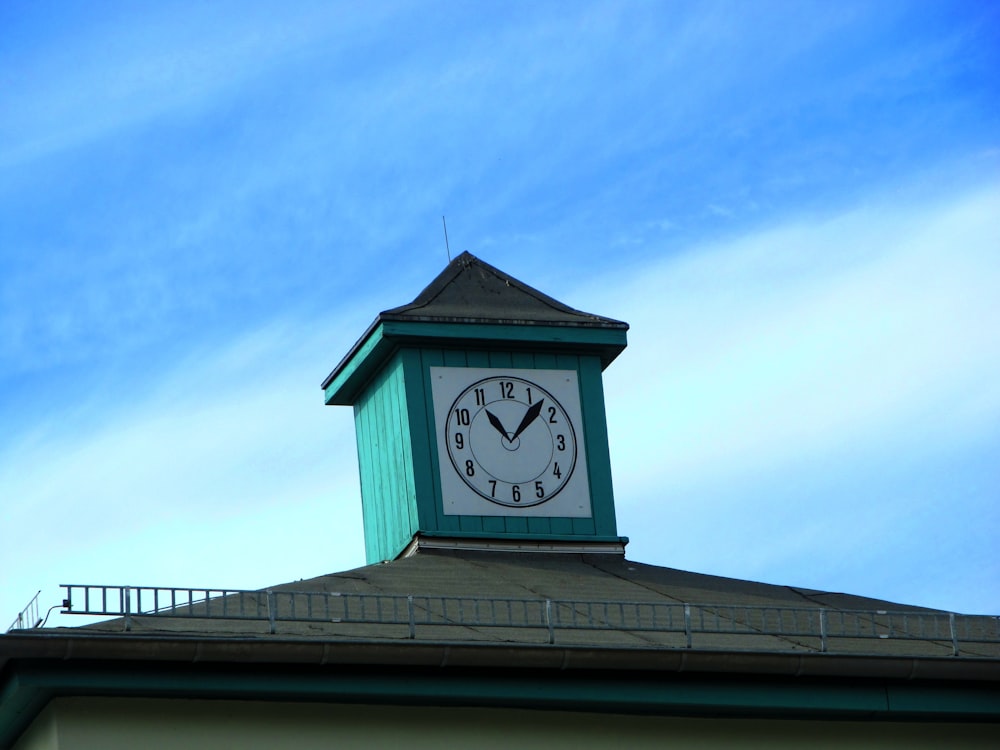 Un reloj en la parte superior de un edificio con un fondo de cielo