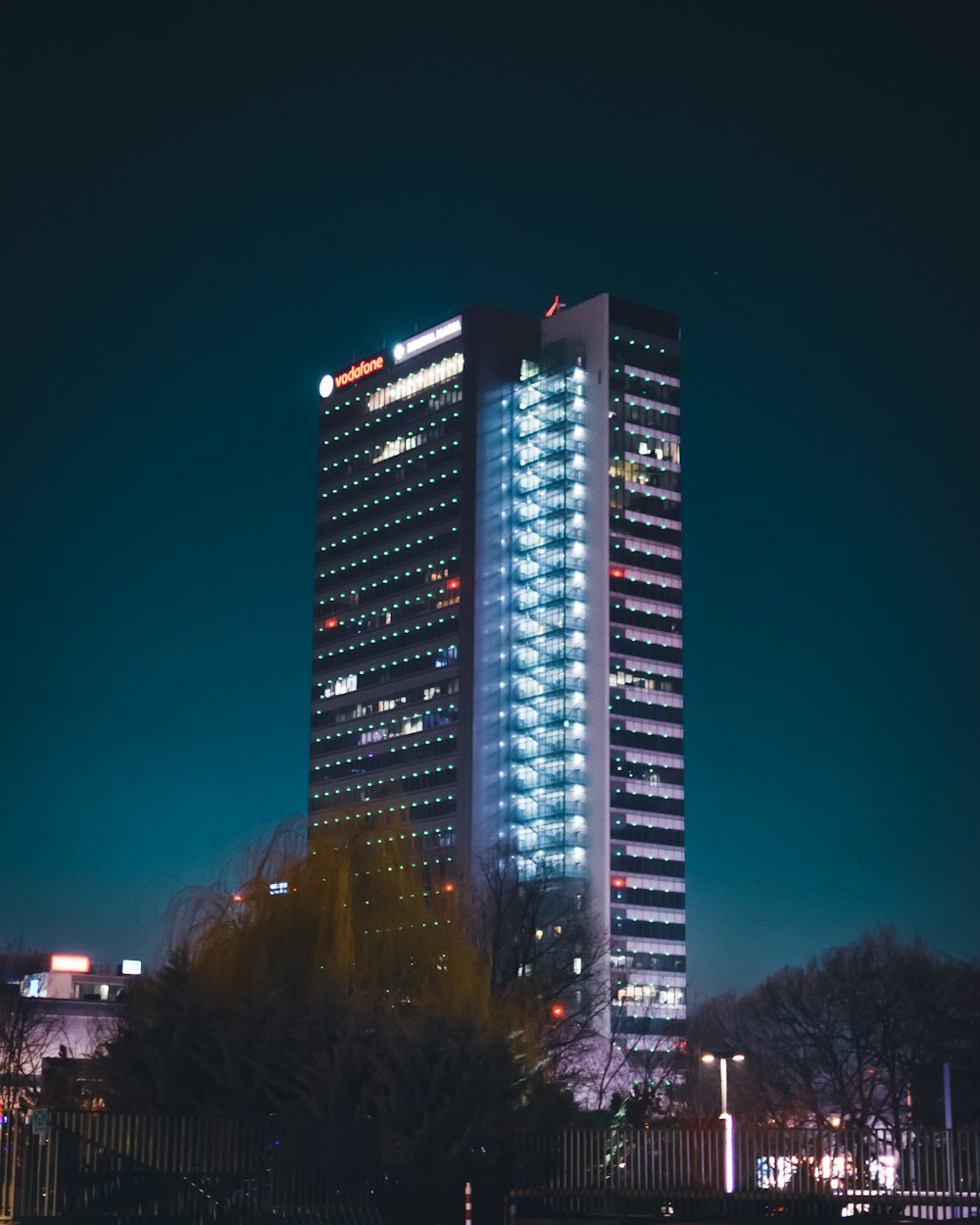 a tall building lit up at night in a city