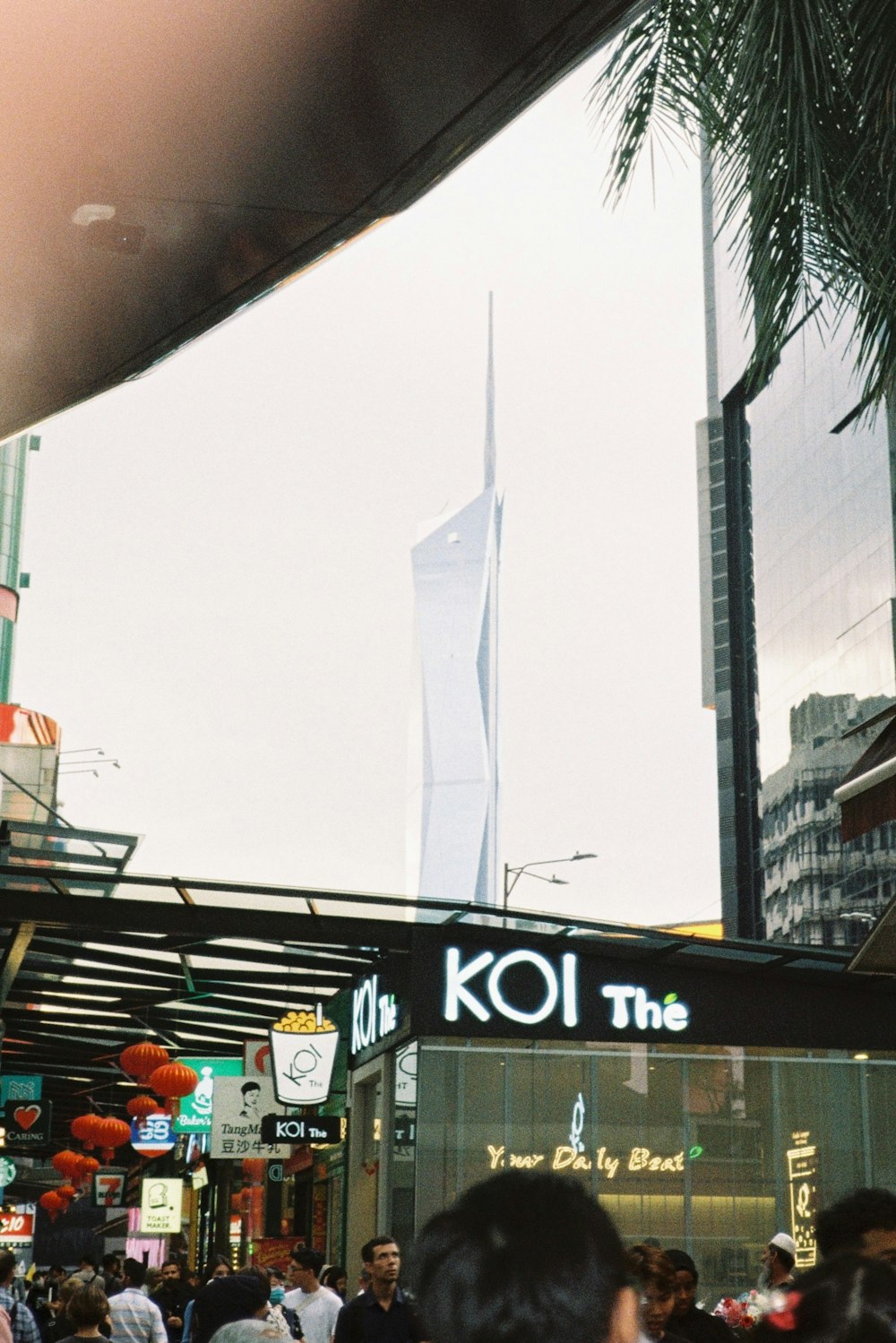 a crowd of people walking down a street next to tall buildings