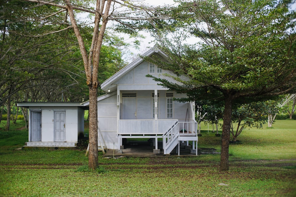 a small white house with a porch and stairs