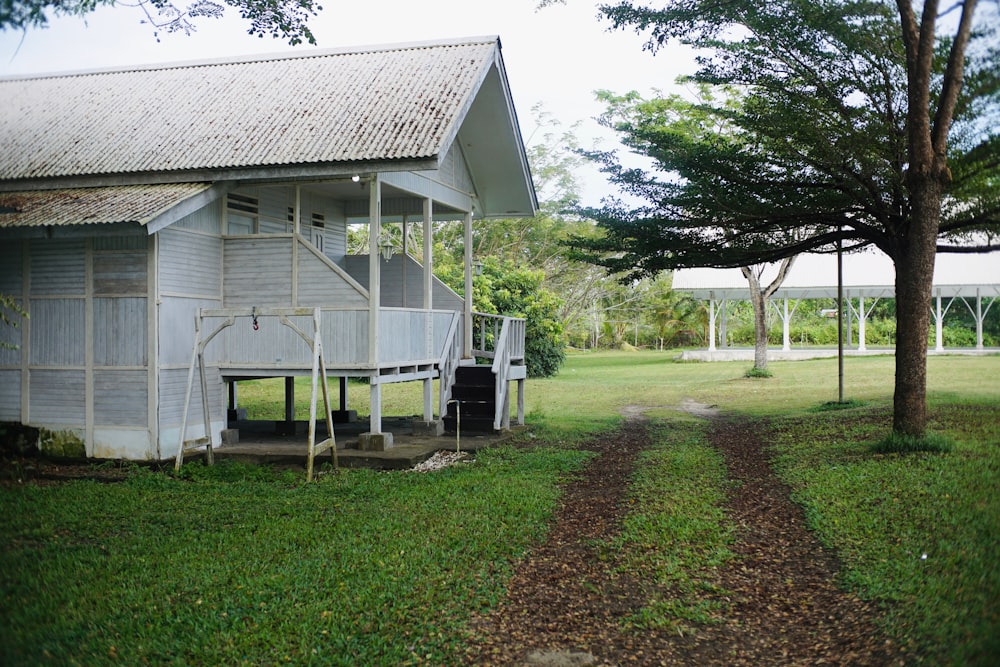 a small white house sitting in the middle of a field