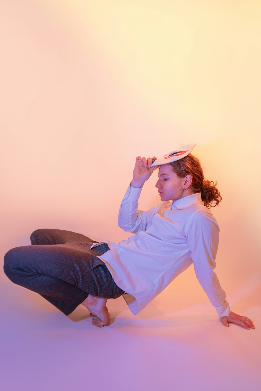 a woman sitting on the ground with a hat on her head