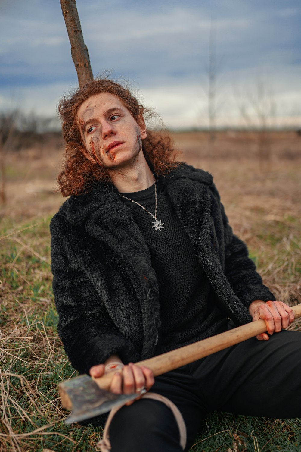 a man sitting on the ground with a stick in his hand