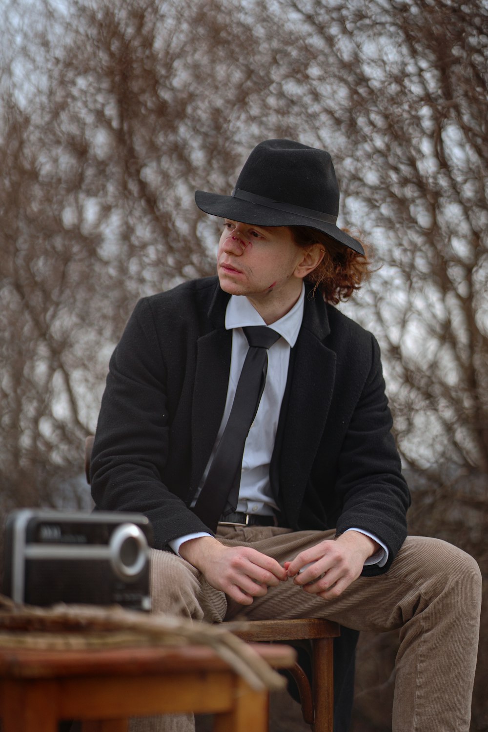 a man sitting on a table wearing a black hat