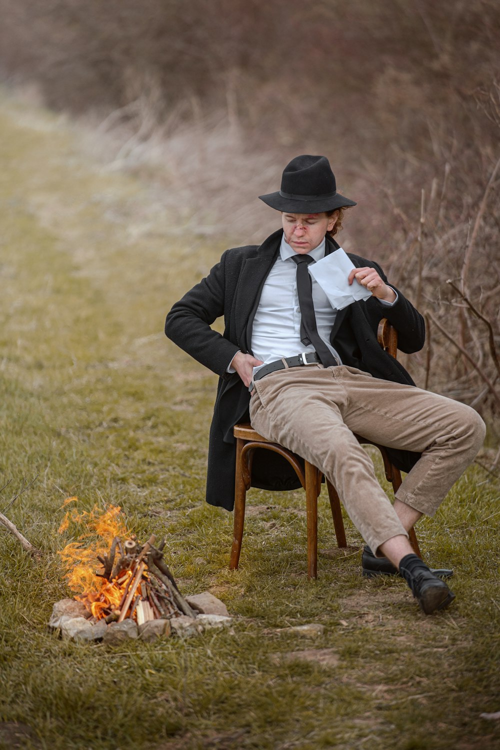 un homme assis sur une chaise près d’un feu