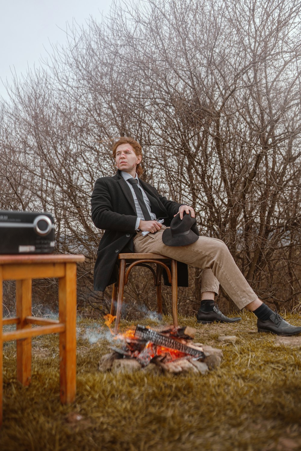 a man sitting in a chair next to a fire