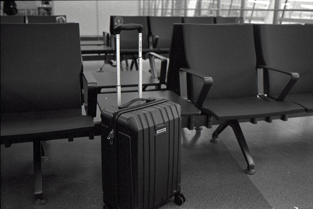 a black and white photo of chairs and luggage