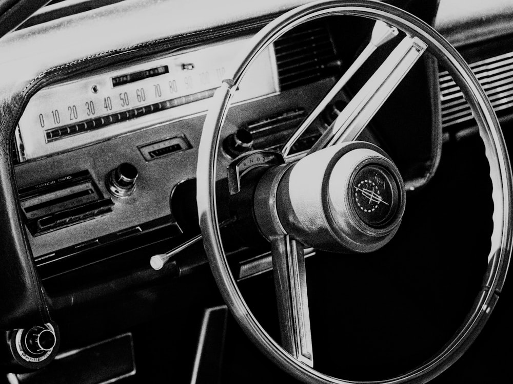 a black and white photo of a steering wheel and dashboard