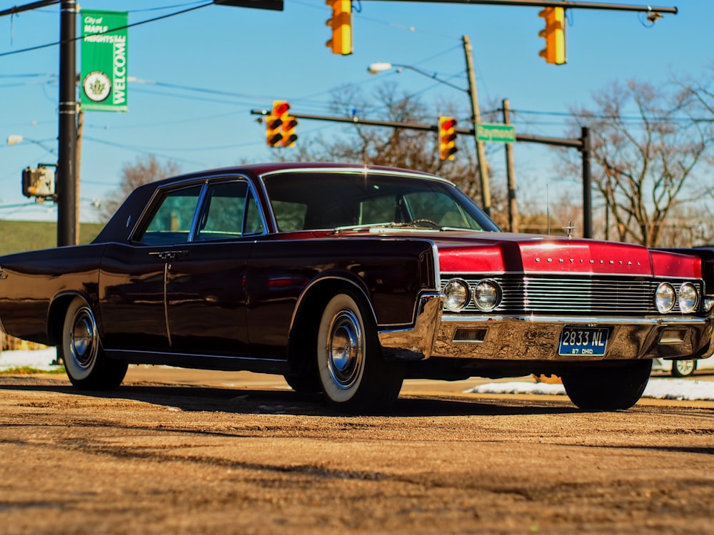 a red and black car parked on the side of the road