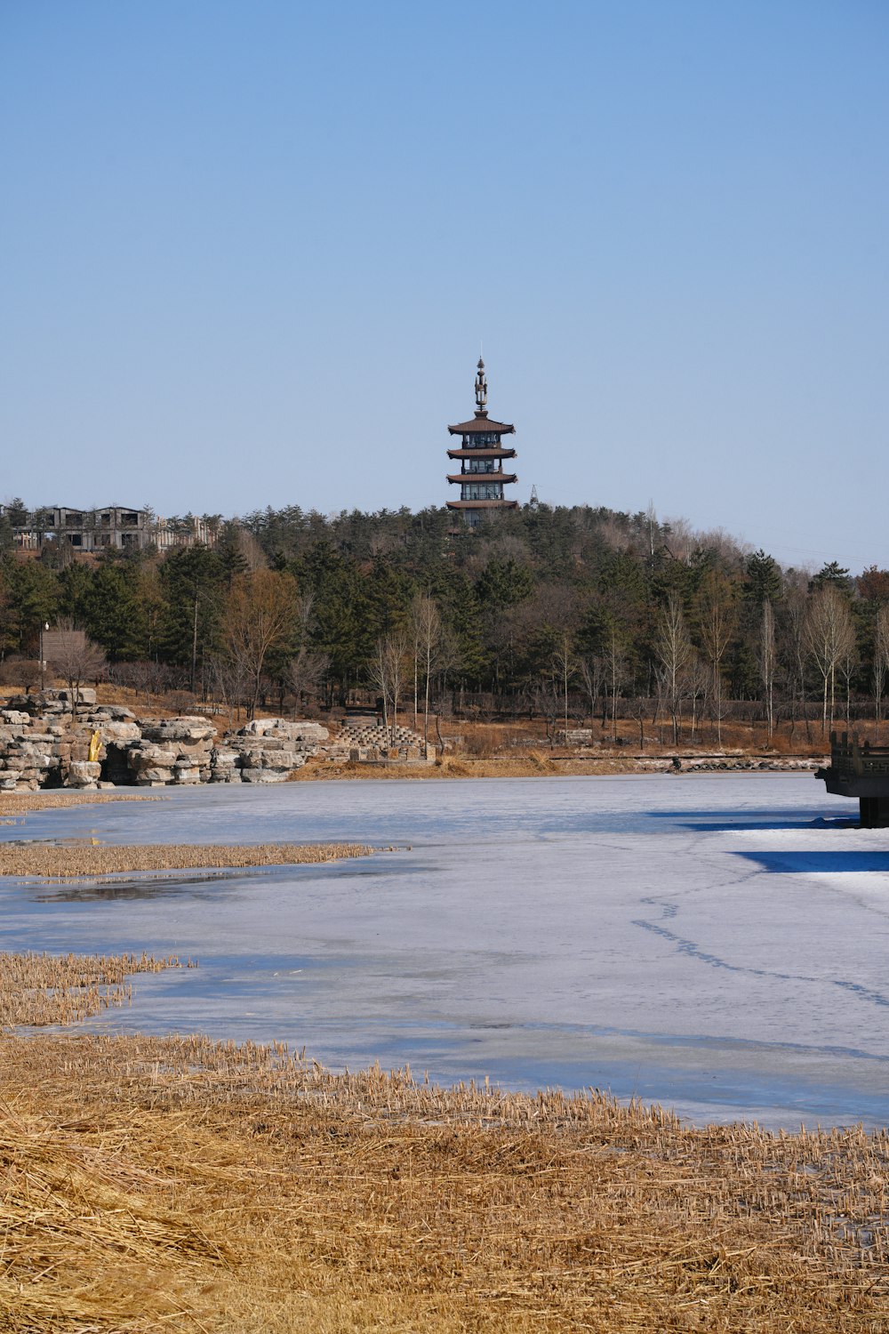 a tall tower sitting on top of a hill next to a body of water