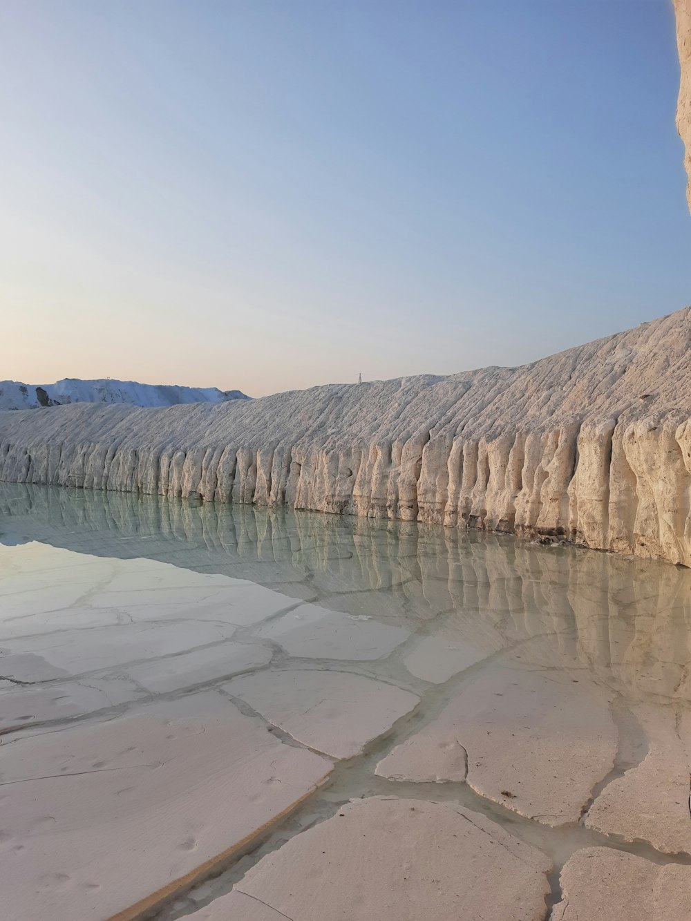 a body of water surrounded by snow covered mountains