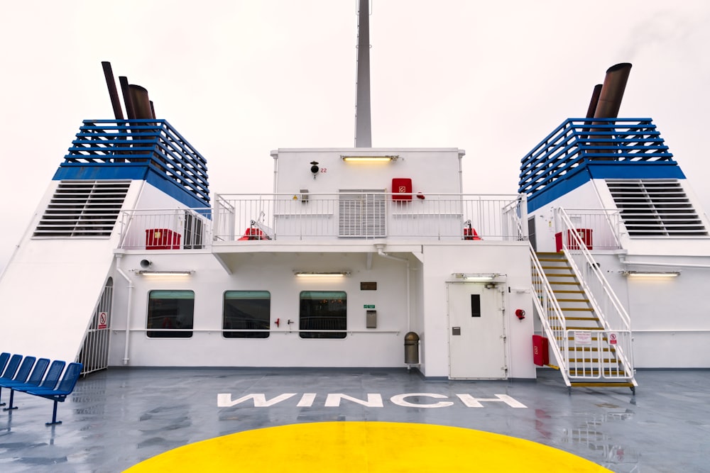 un bateau blanc et bleu avec des escaliers qui y mènent