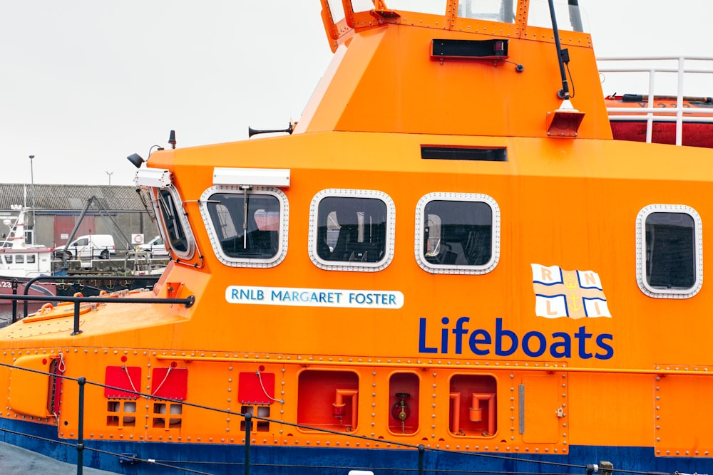 a large orange boat sitting in a harbor