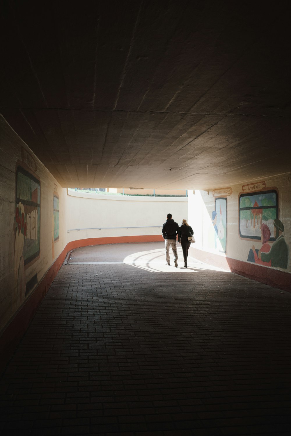 a couple of people that are walking in a tunnel