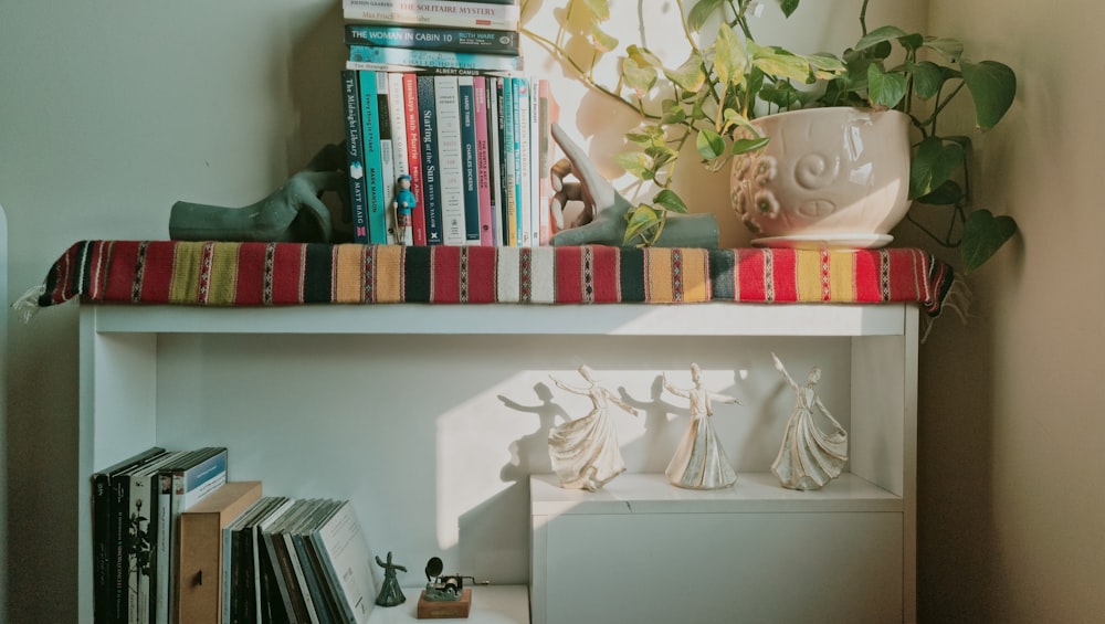 a shelf with books and figurines on top of it
