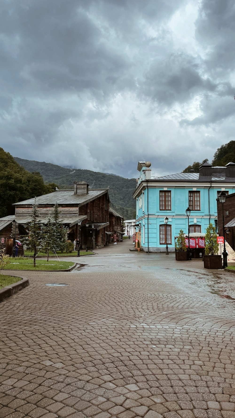 a cobblestone street with a blue building in the background