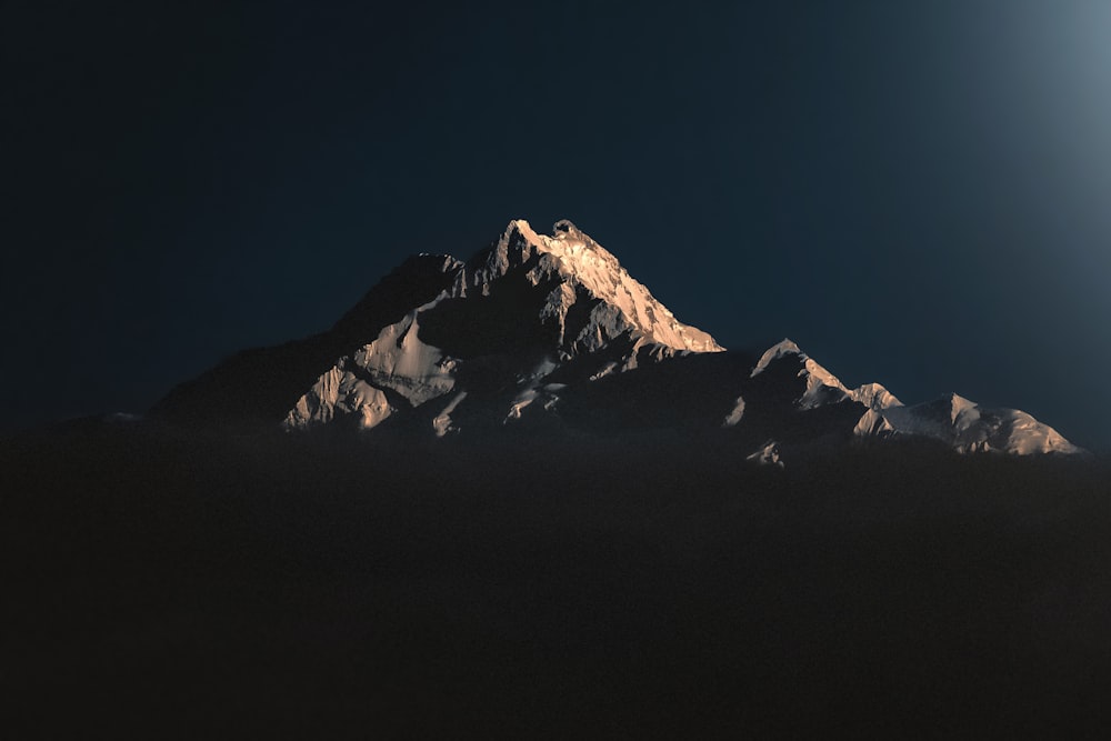 Uma lua cheia brilha em uma montanha nevada