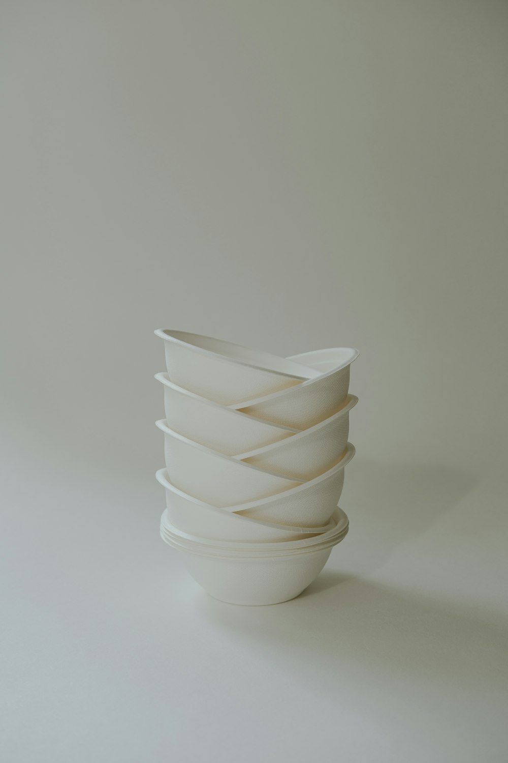 eine weiße Vase, die auf einem weißen Tisch steht