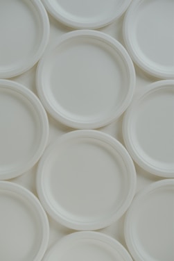a bunch of white plates stacked on top of each other
