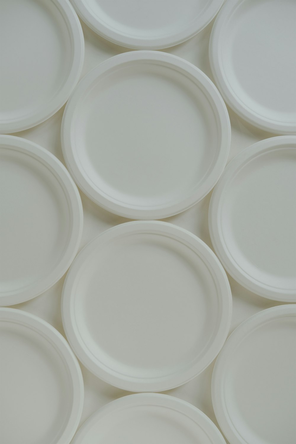 a bunch of white plates stacked on top of each other