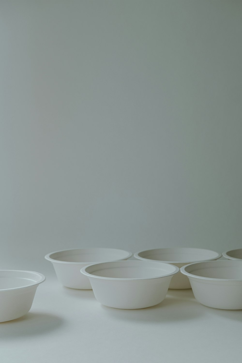 a group of white bowls sitting on top of a table