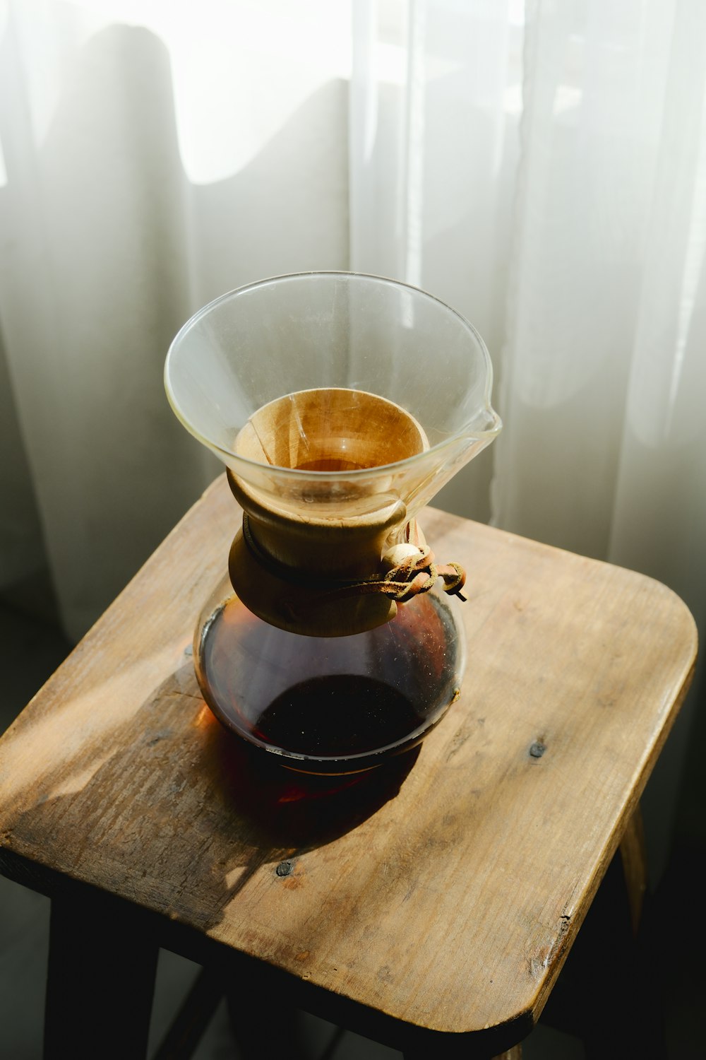 a pitcher of liquid sitting on top of a wooden table