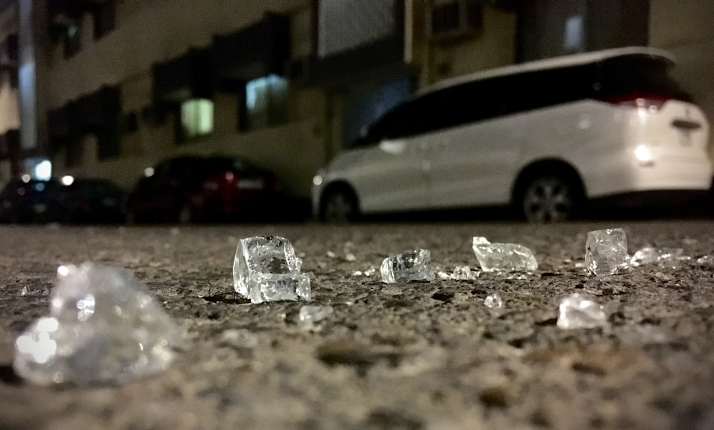 some ice cubes on the ground next to a car