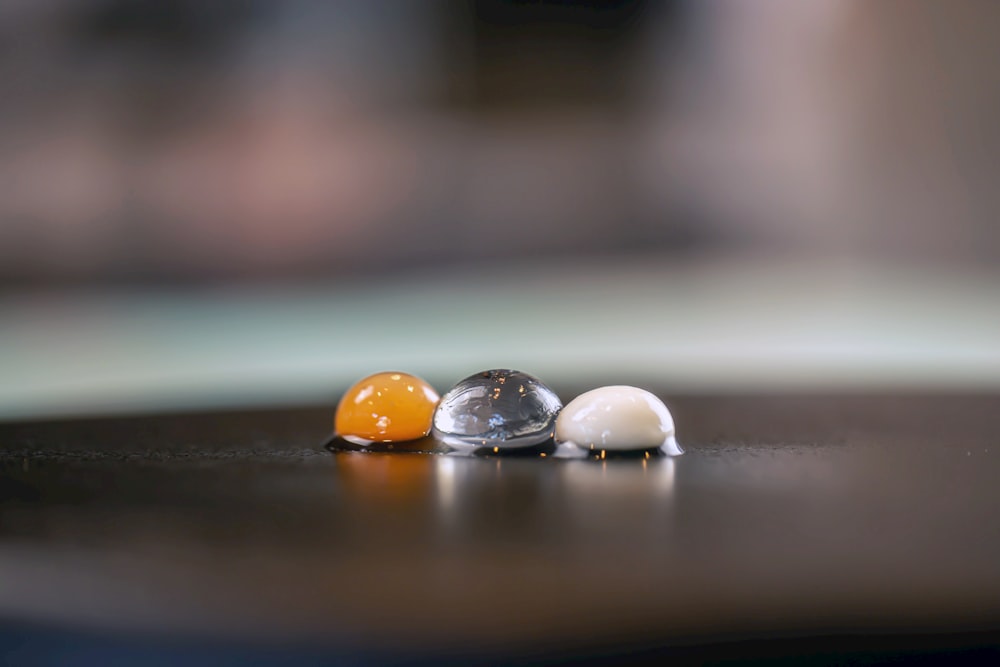 three marbles sitting on top of a wooden table