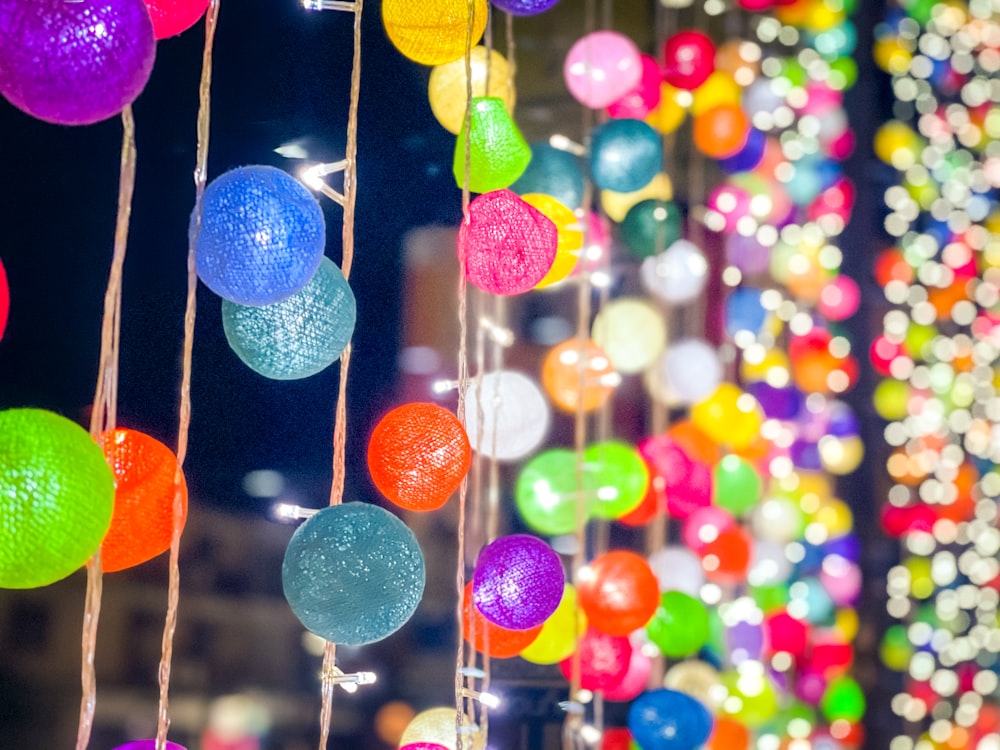 a bunch of colorful balls hanging from strings