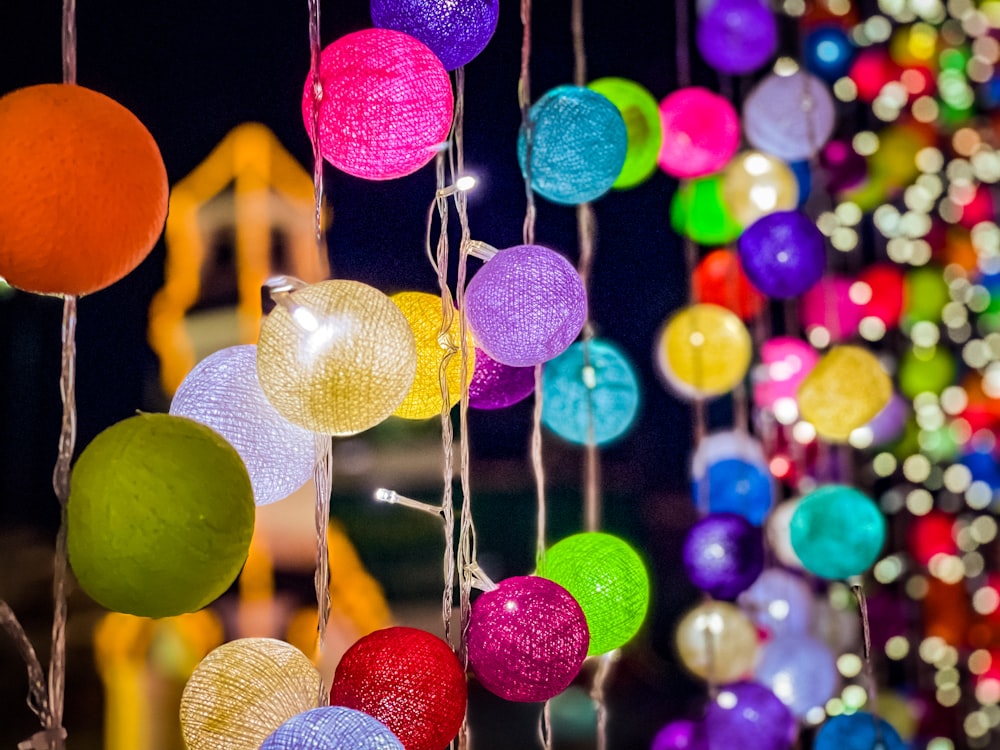 a bunch of colorful balls hanging from strings