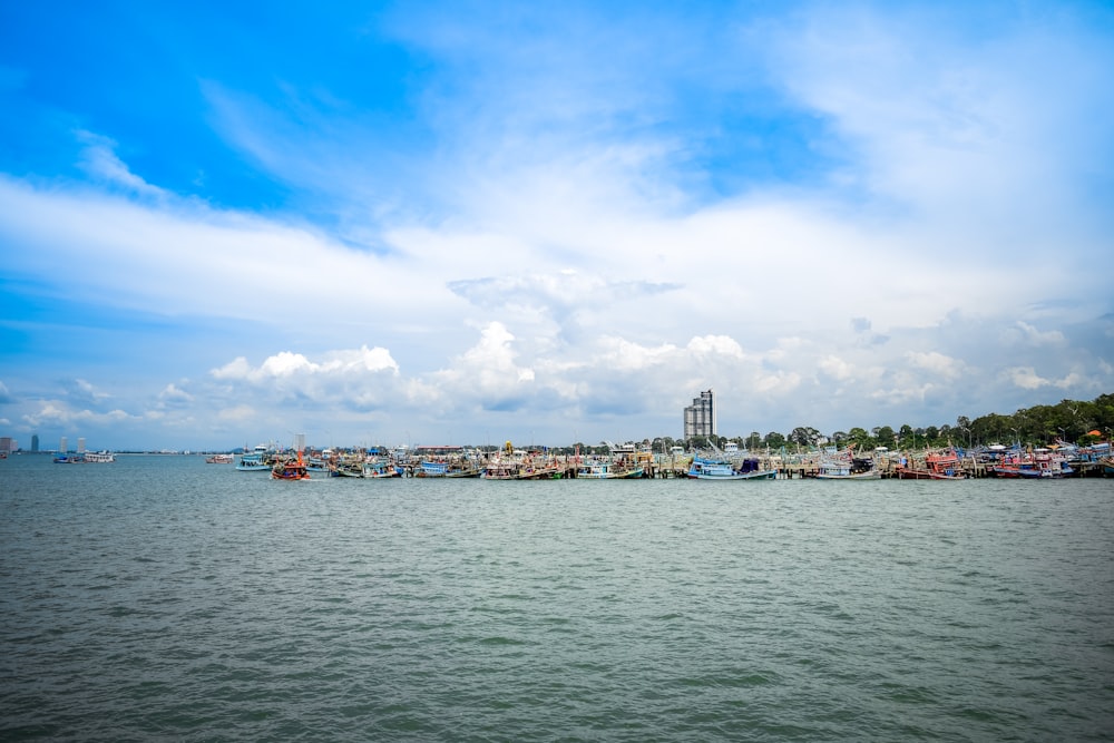 a harbor filled with lots of boats under a cloudy blue sky