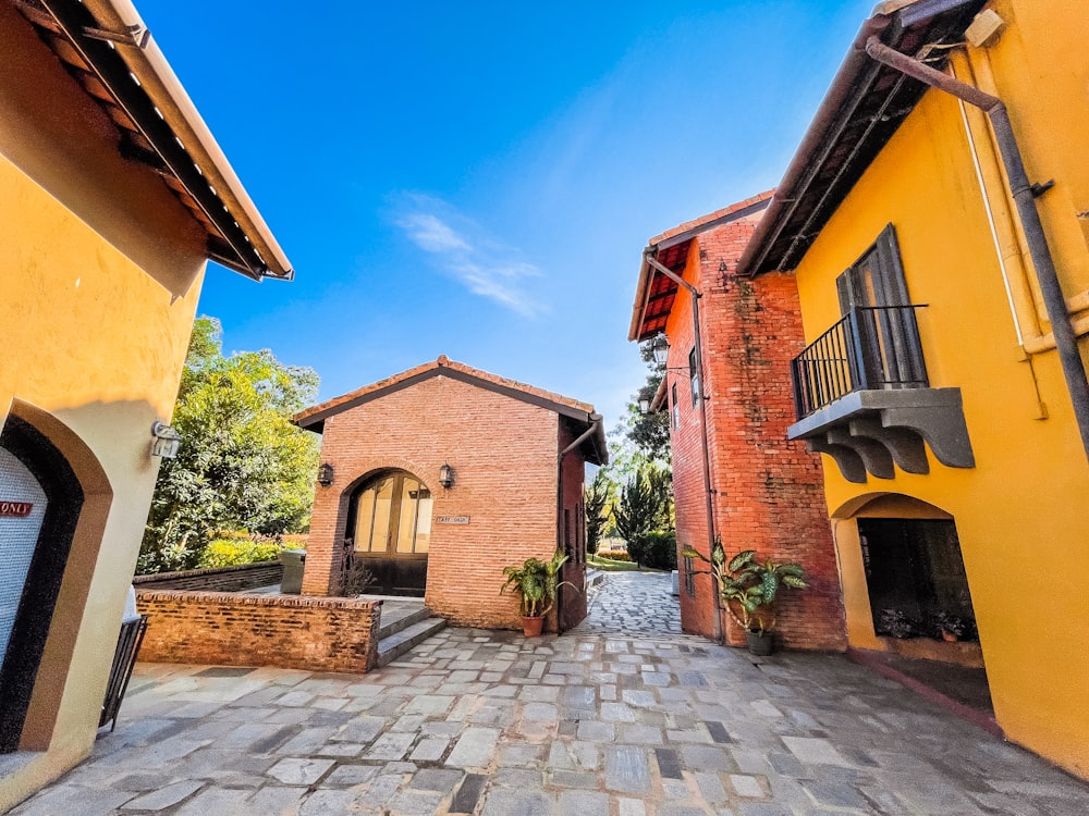 an alley way with a brick building and a blue sky