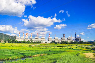 a power plant in the middle of a green field