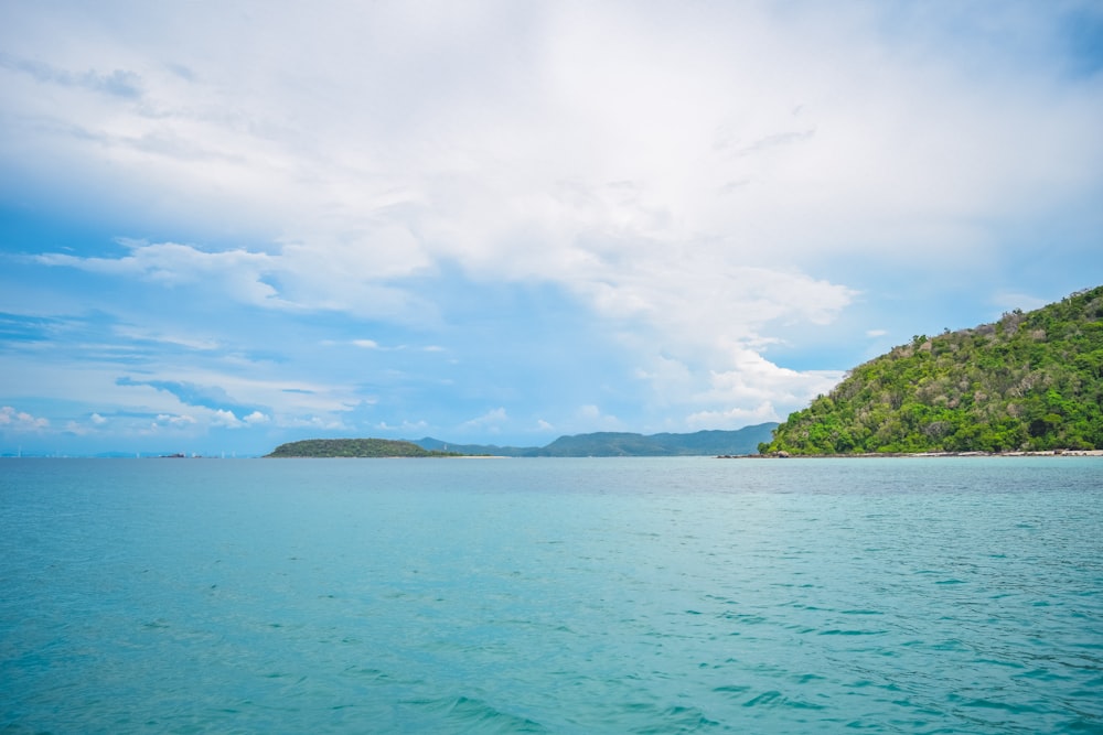 a body of water with a hill in the background