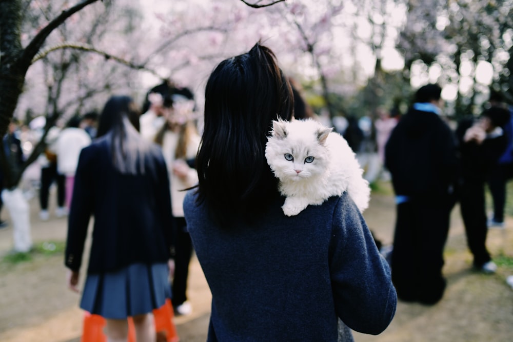 a woman holding a white cat in her arms