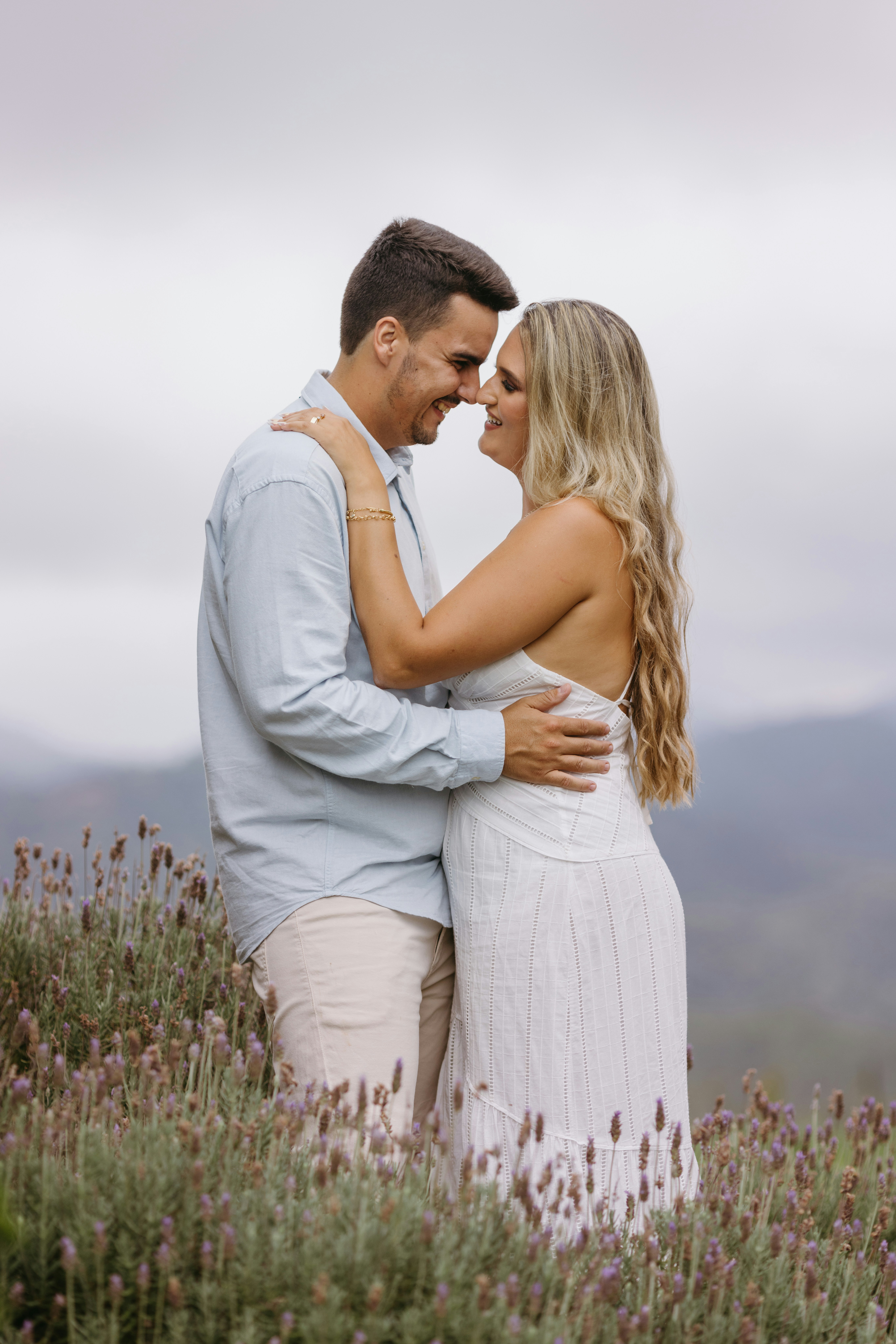 a man and a woman embracing in a field of flowers