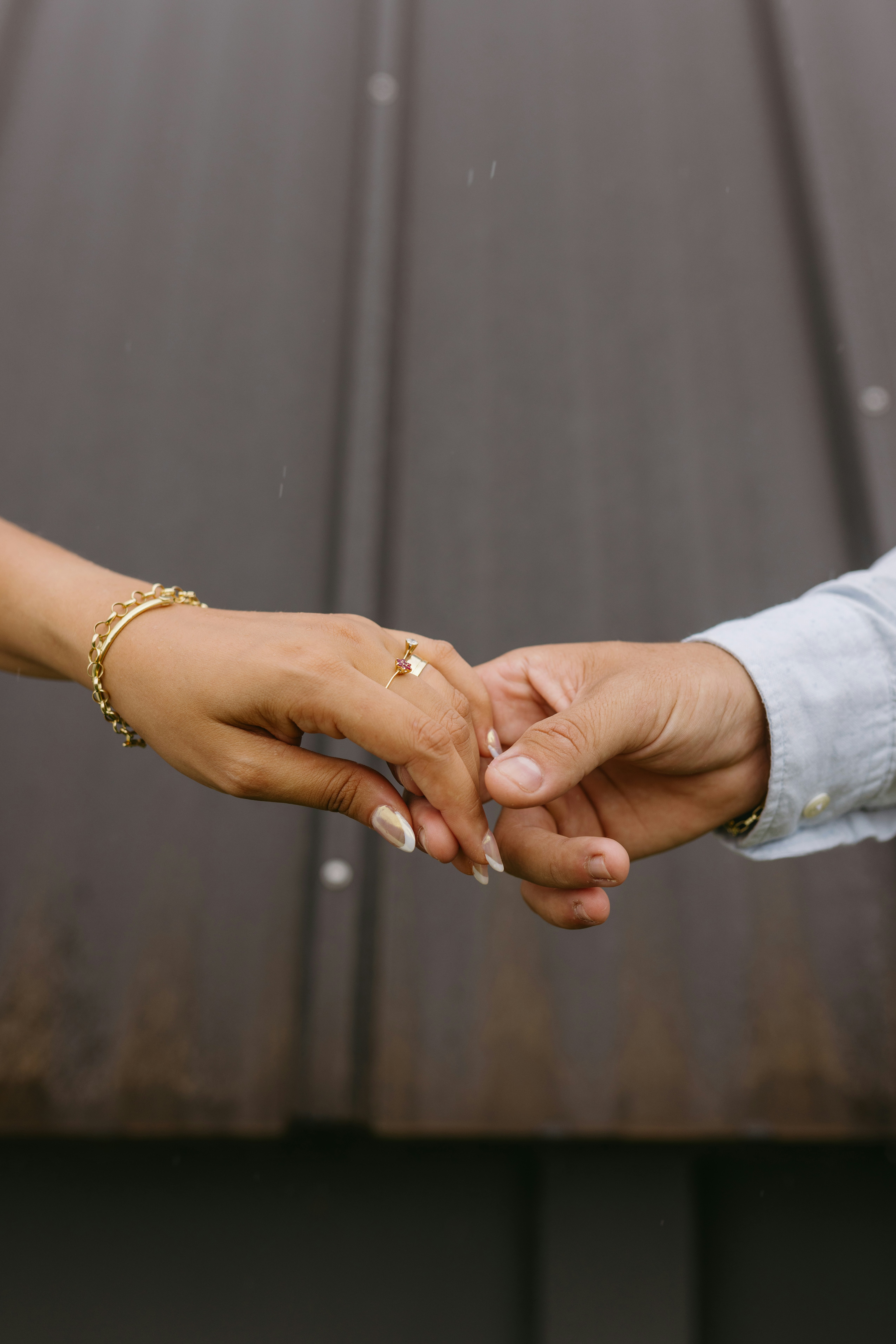 a close up of two people holding hands