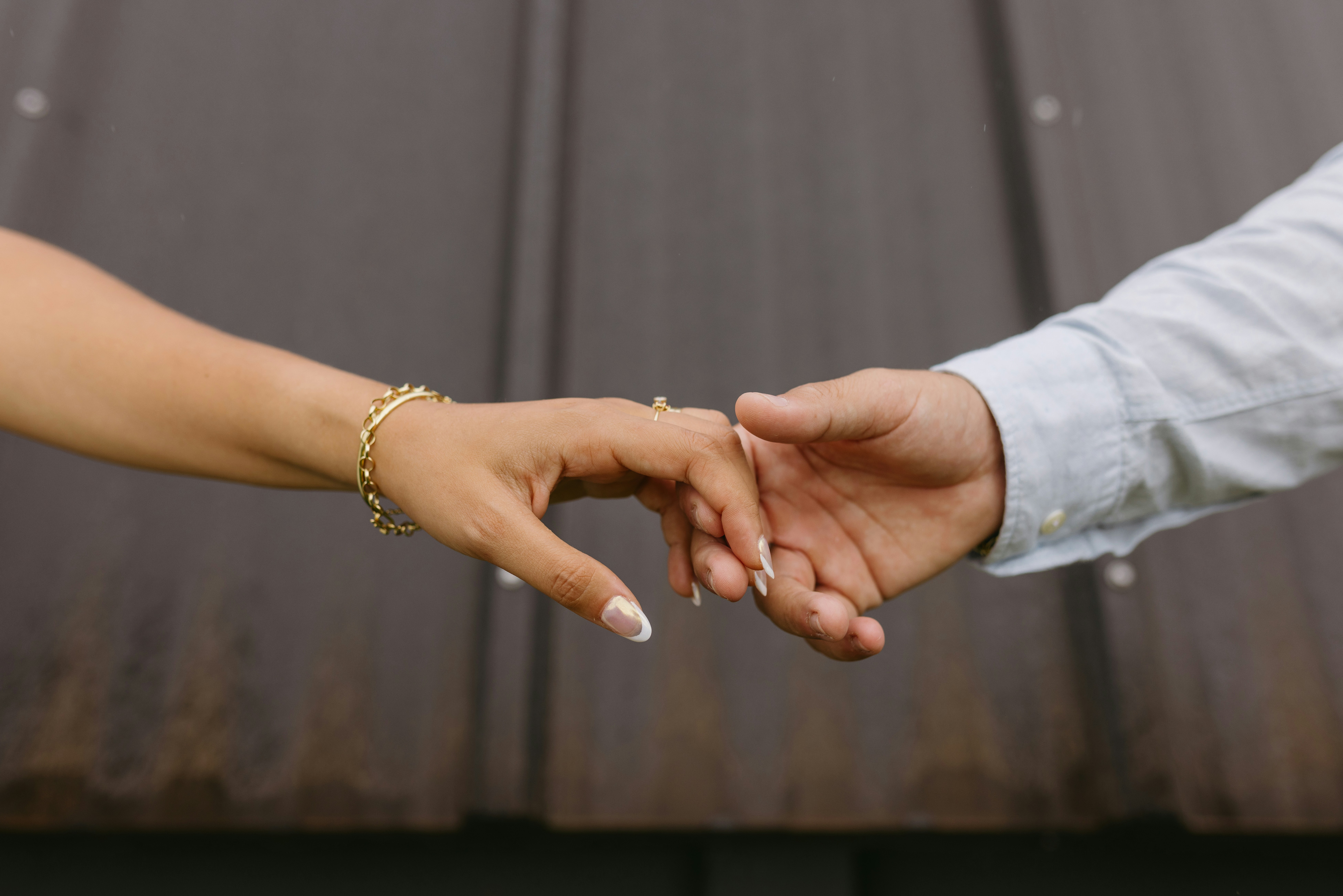 a close up of two people holding hands