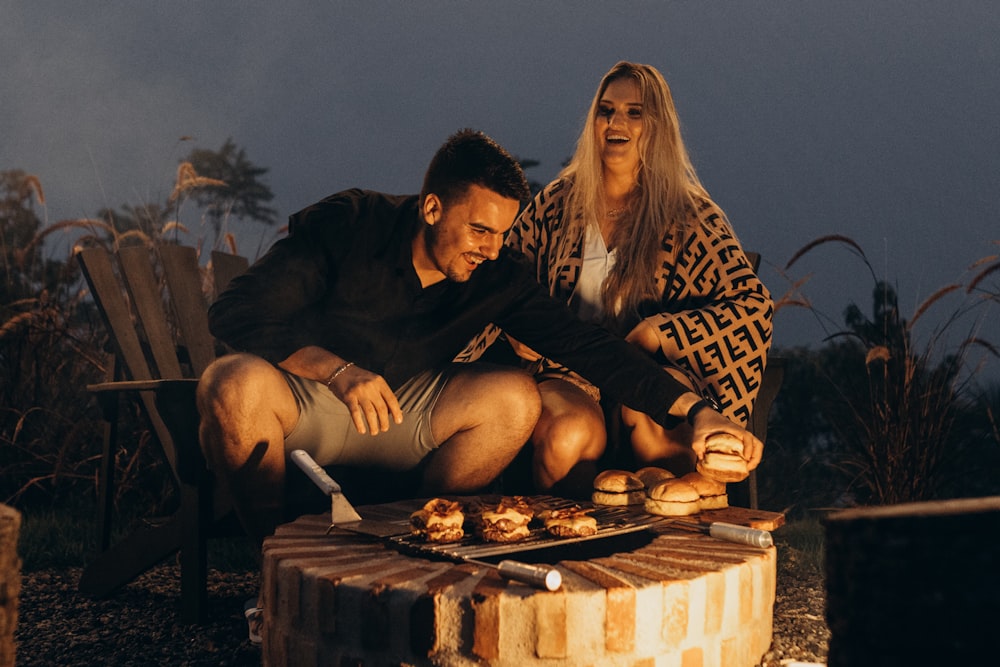 a man and a woman sitting on a wooden table