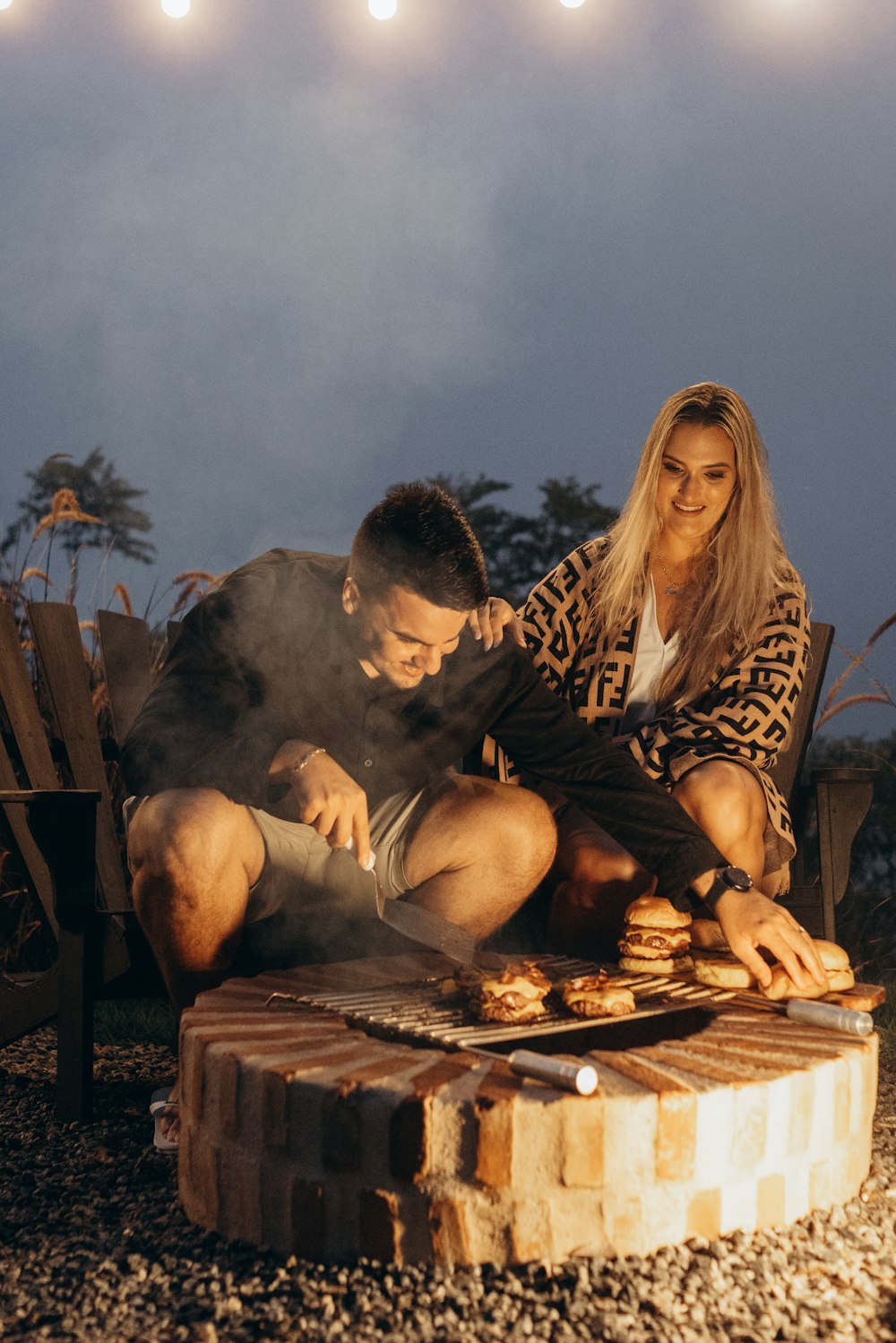 Ein Mann und eine Frau sitzen auf einer Feuerstelle