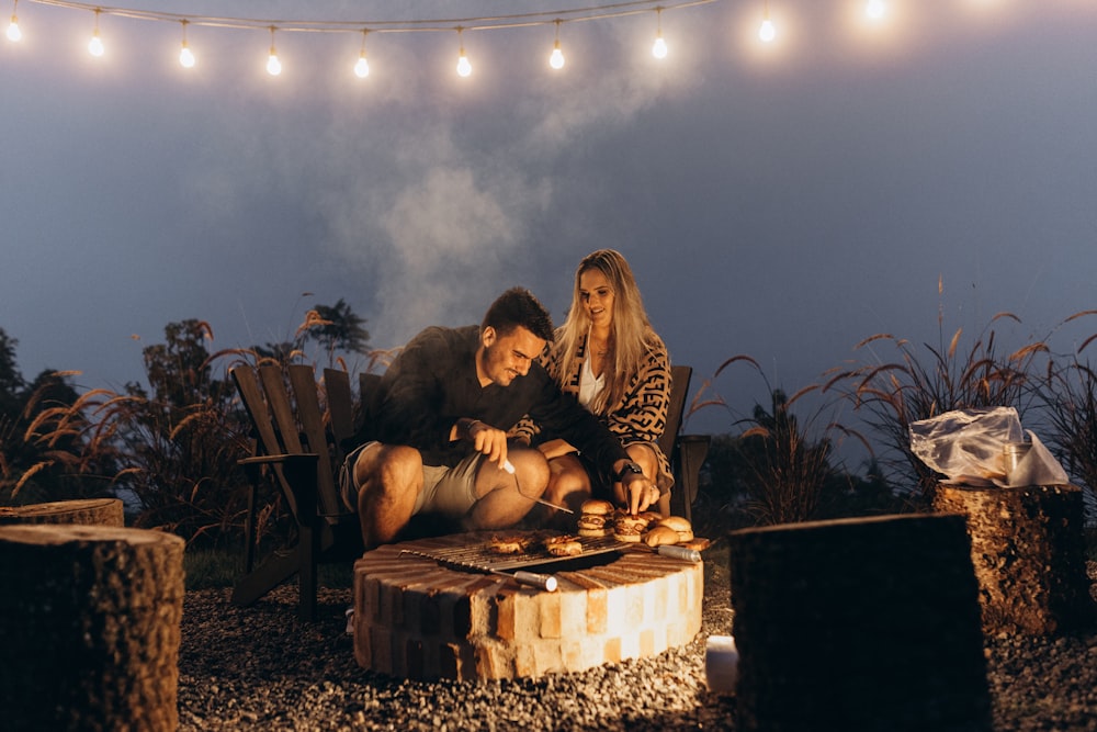 a man and a woman are sitting on a tree stump