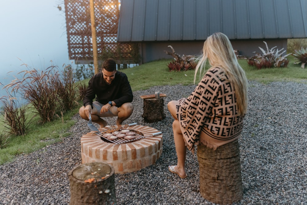 a man and a woman sitting on a tree stump