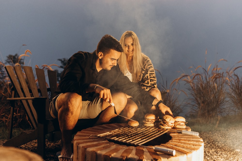 a man and a woman cooking on a grill