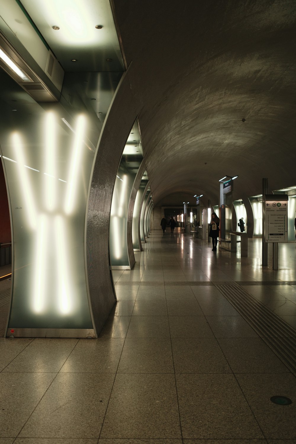 an empty subway station with people walking around