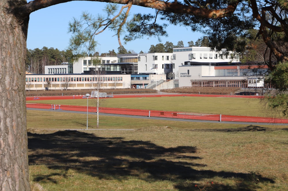 a large white building sitting next to a lush green field